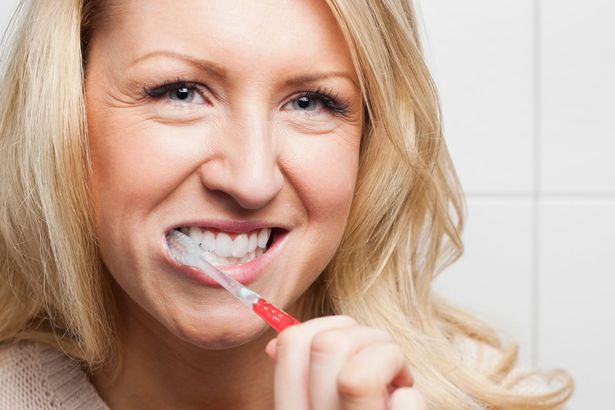 Woman-brushing-teeth-in-bathroom